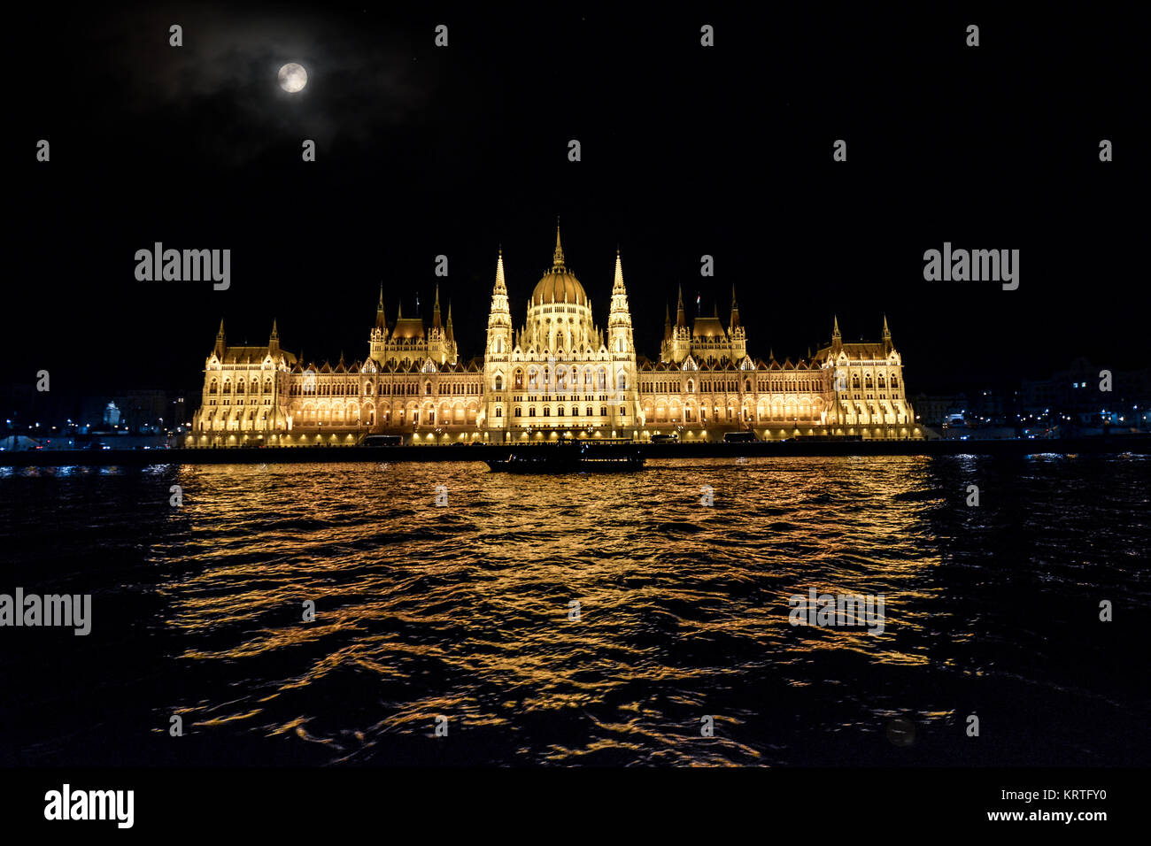 A late night cruise along the Danube River in Budapest Hungary under a full moon with the Budapest Parliament building lit up Stock Photo