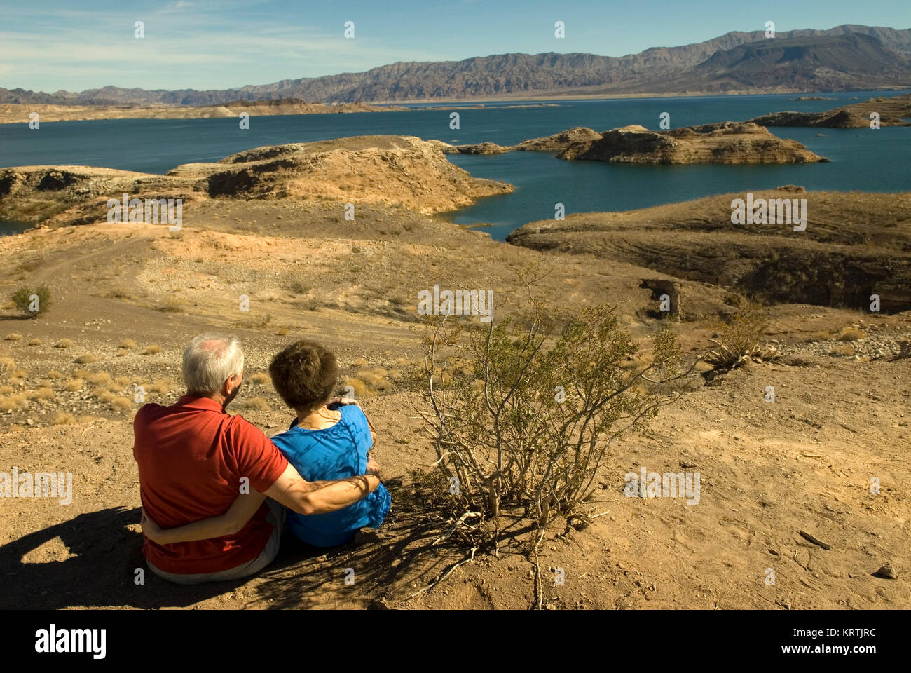 Couple sits on beach at Lake Mead National Recreation Area Nevada, USA. Stock Photo