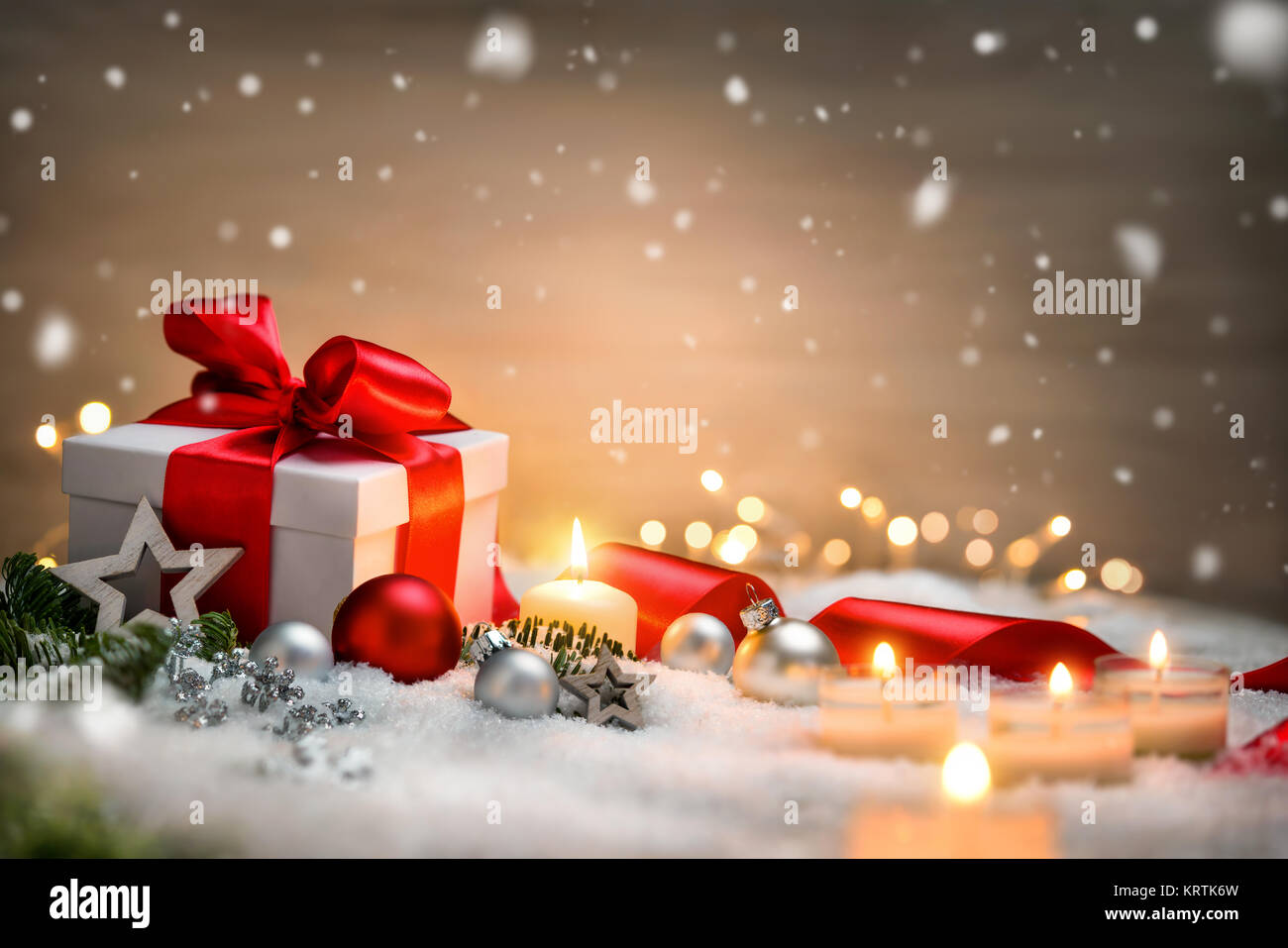 christmas background with gift and red ribbon,candles,christmas lights,christmas and snow Stock Photo