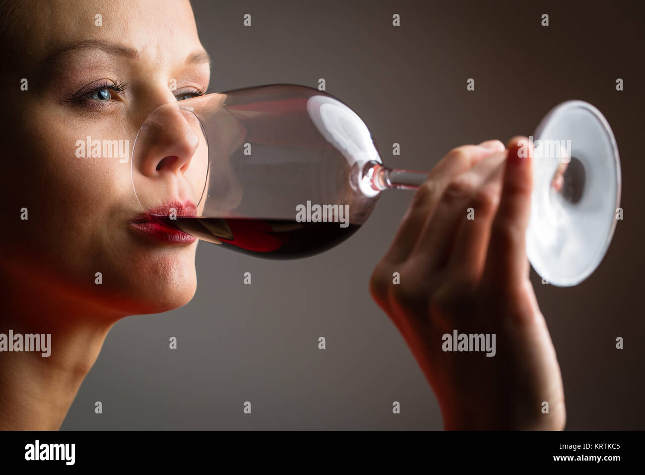 Elegant young woman in a red dress, having a glass of red wine Stock ...