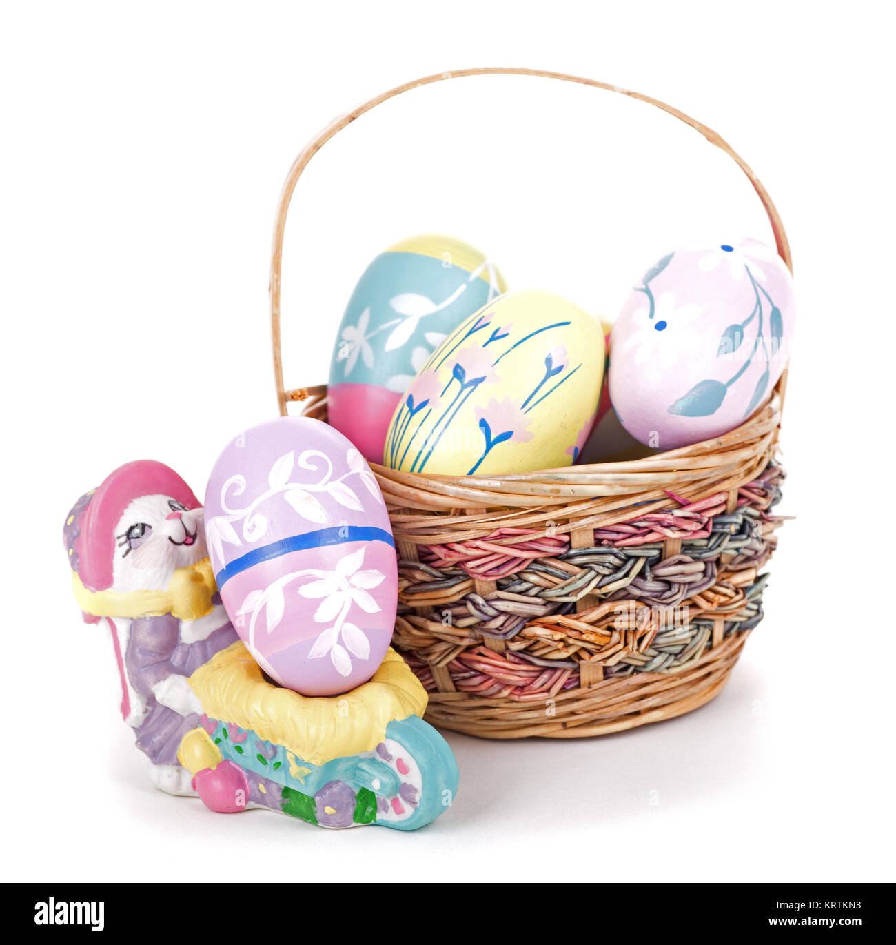 Basket of colorful Easter eggs and bunny figurine on a white background ...