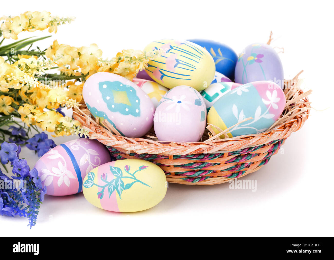 Assortment of colorful Easter eggs and basket on a white background ...