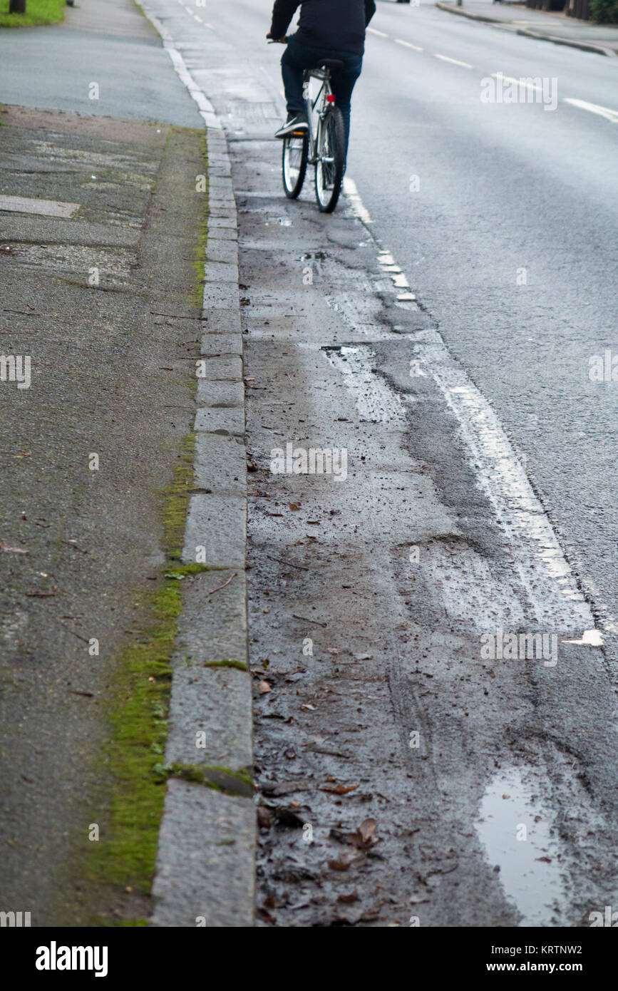 Cyclist riding & poor quality broken bicycle / bike / cycle lane