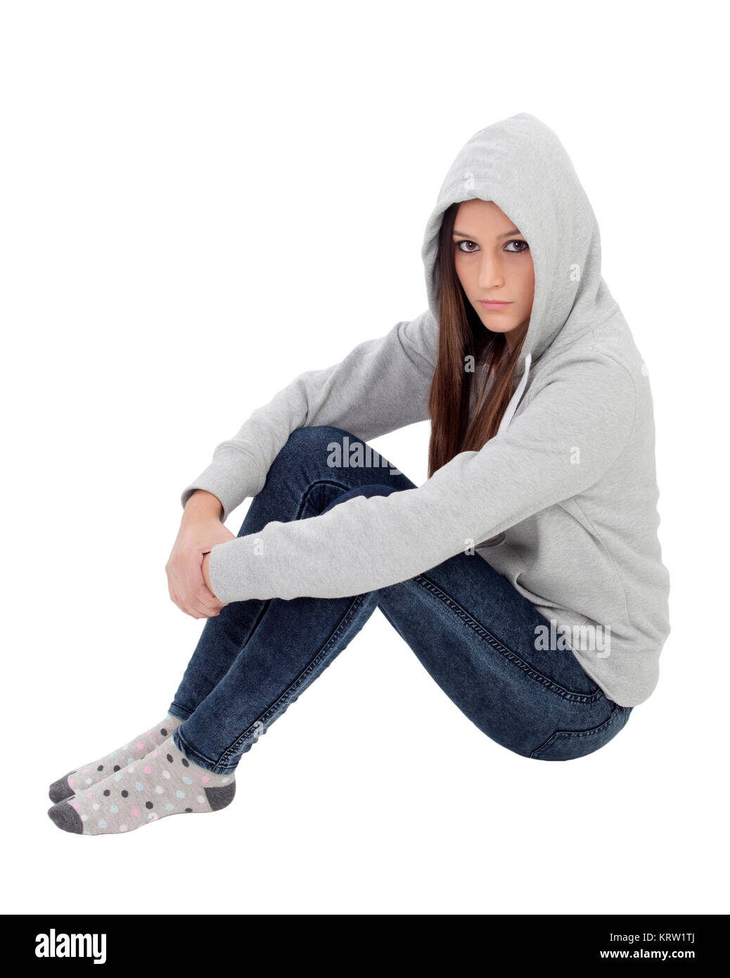 Angry hooded girl with grey sweatshirt sitting on the floor Stock Photo
