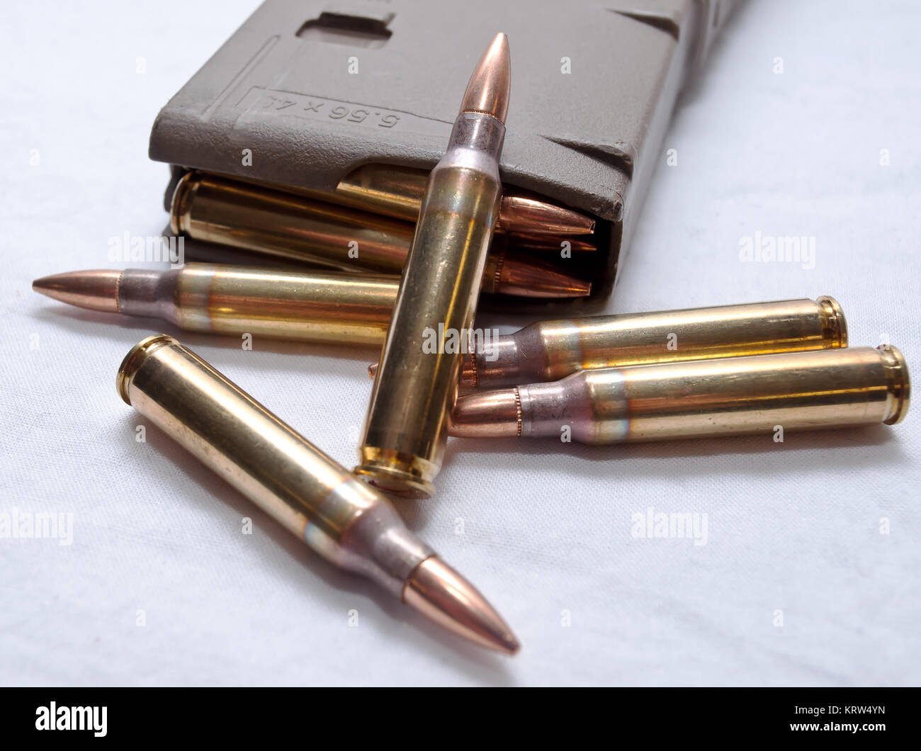 Several .223 caliber rounds and a loaded magazine on a white background Stock Photo