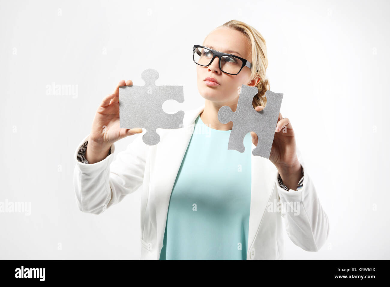 an attractive woman in business attire matches the pieces of the puzzle. Stock Photo