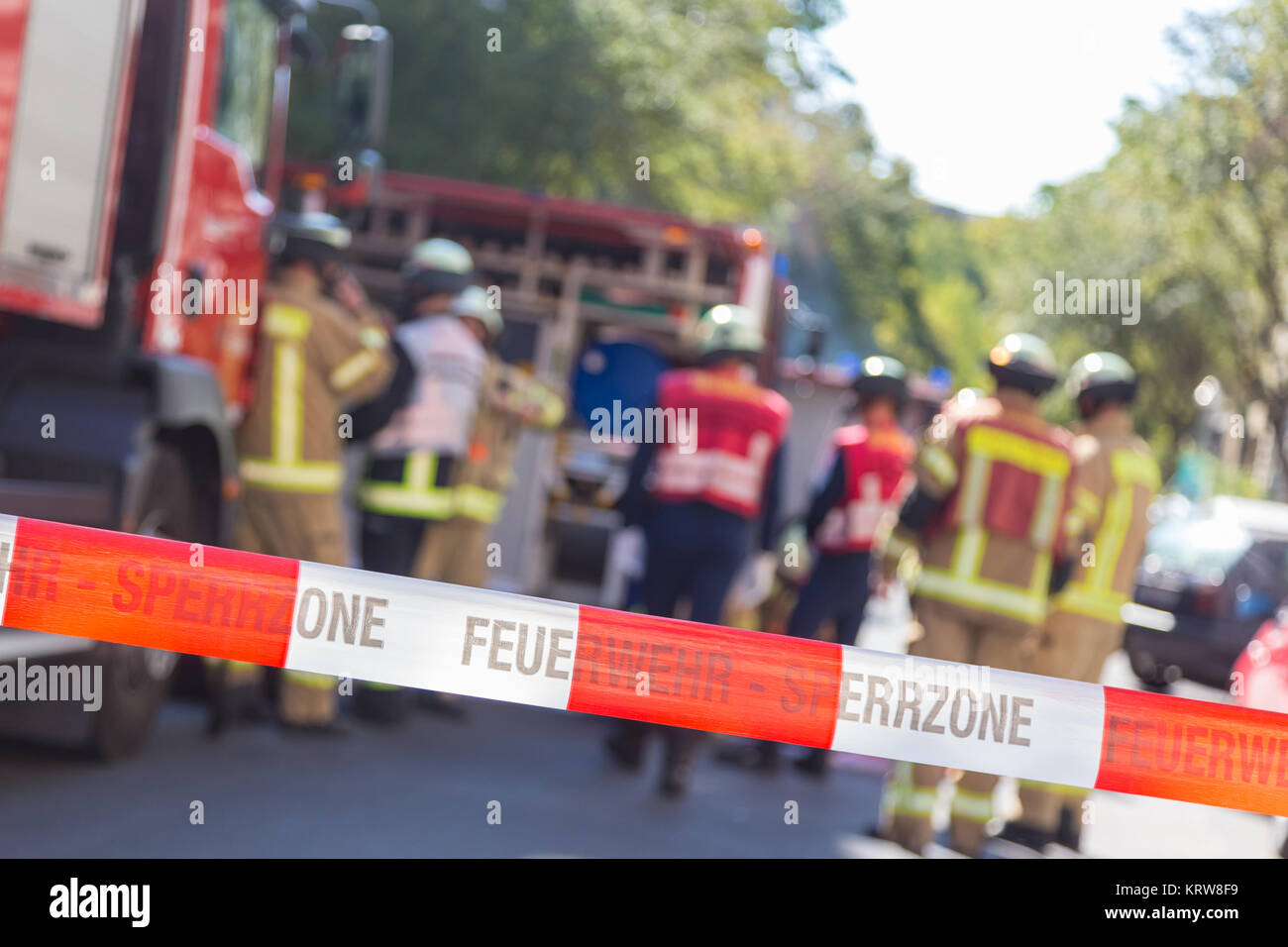 Team of firefighters by firetruck on accident location. Stock Photo