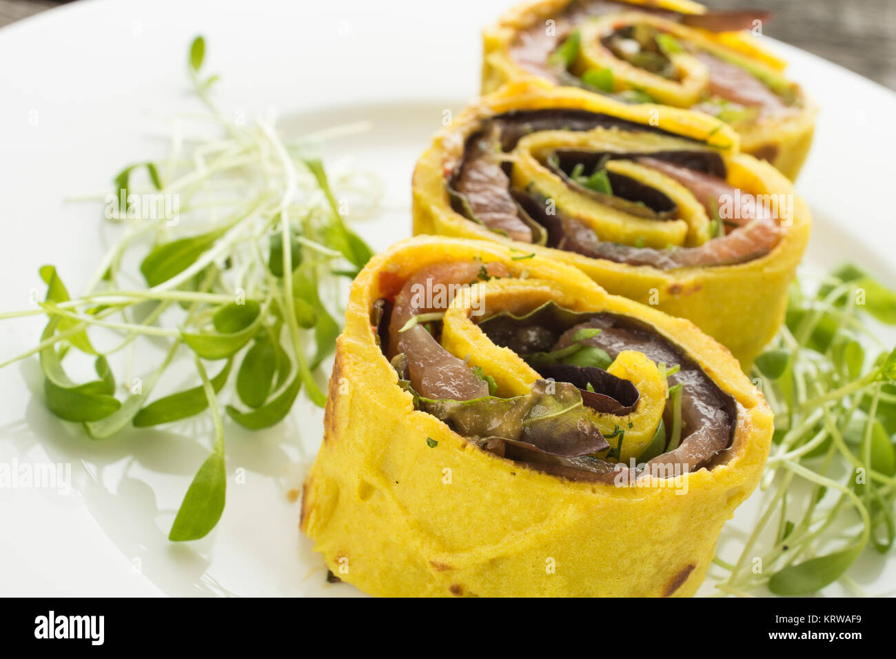 Pfannkuchen Röllchen mit Räucherlachs und Blattsalat gefüllt Stock Photo