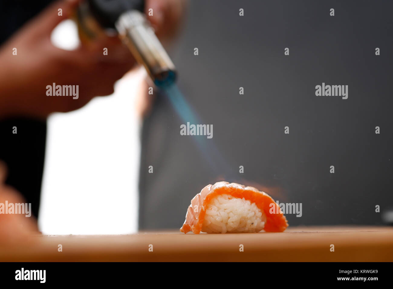 Sushi z surowym Å‚ososiem opalane pÅ‚omieniem. Porcja ryÅ¼u uformowanego w kulkÄ™ przykrytego kawaÅ‚kiem ryby Stock Photo