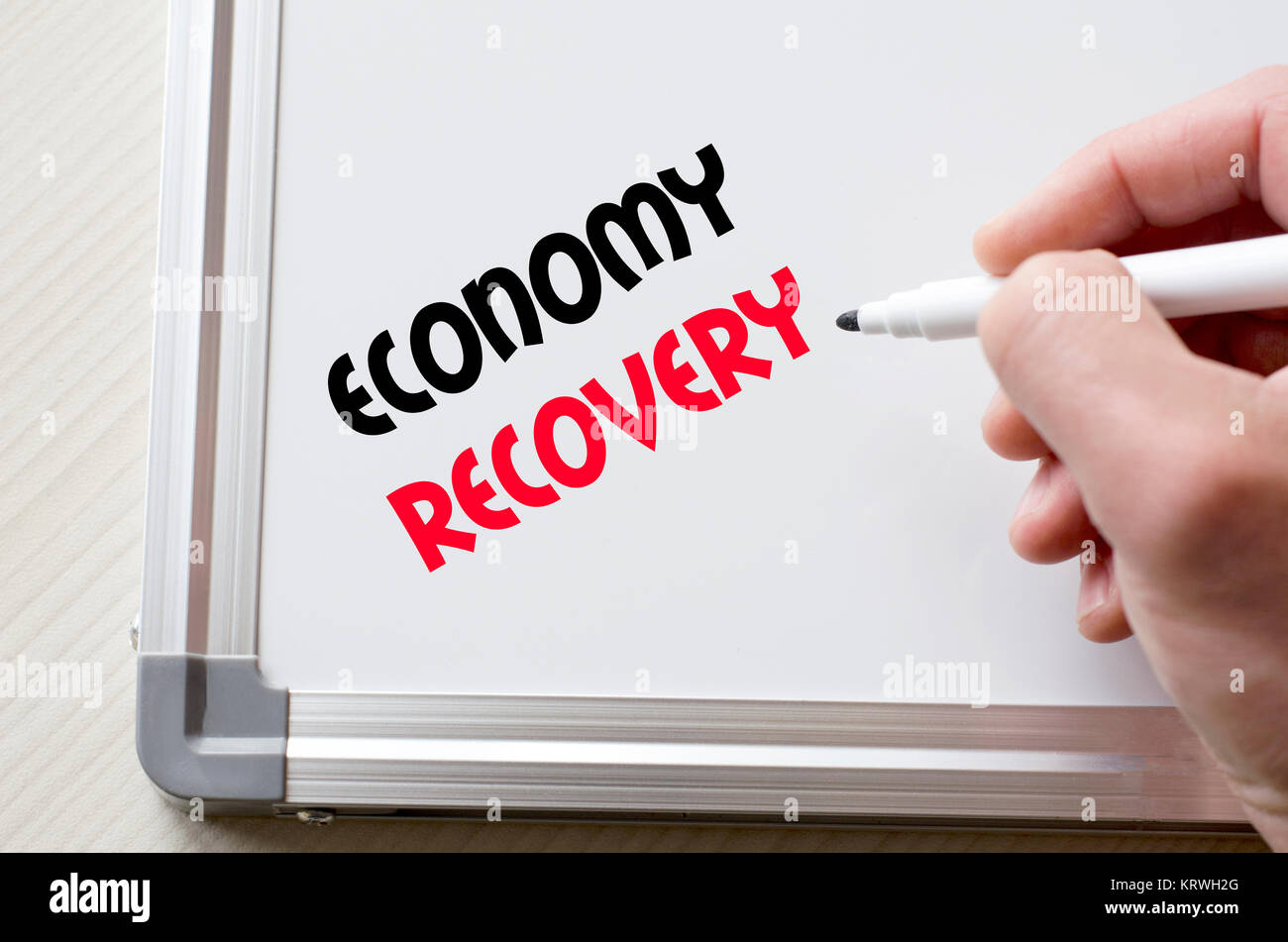 Economy recovery written on whiteboard Stock Photo