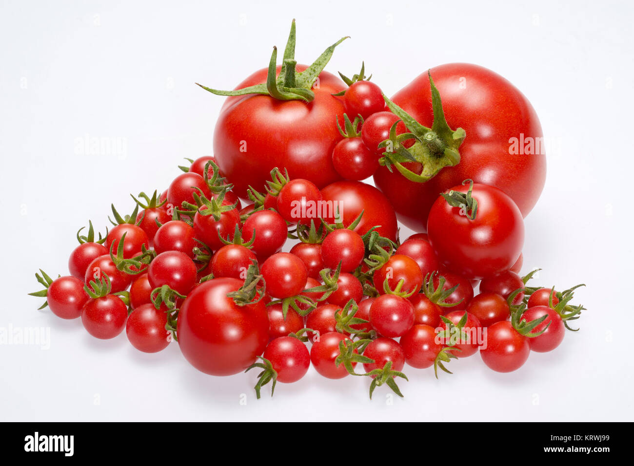 pile of various red tomatoes in light back Stock Photo - Alamy