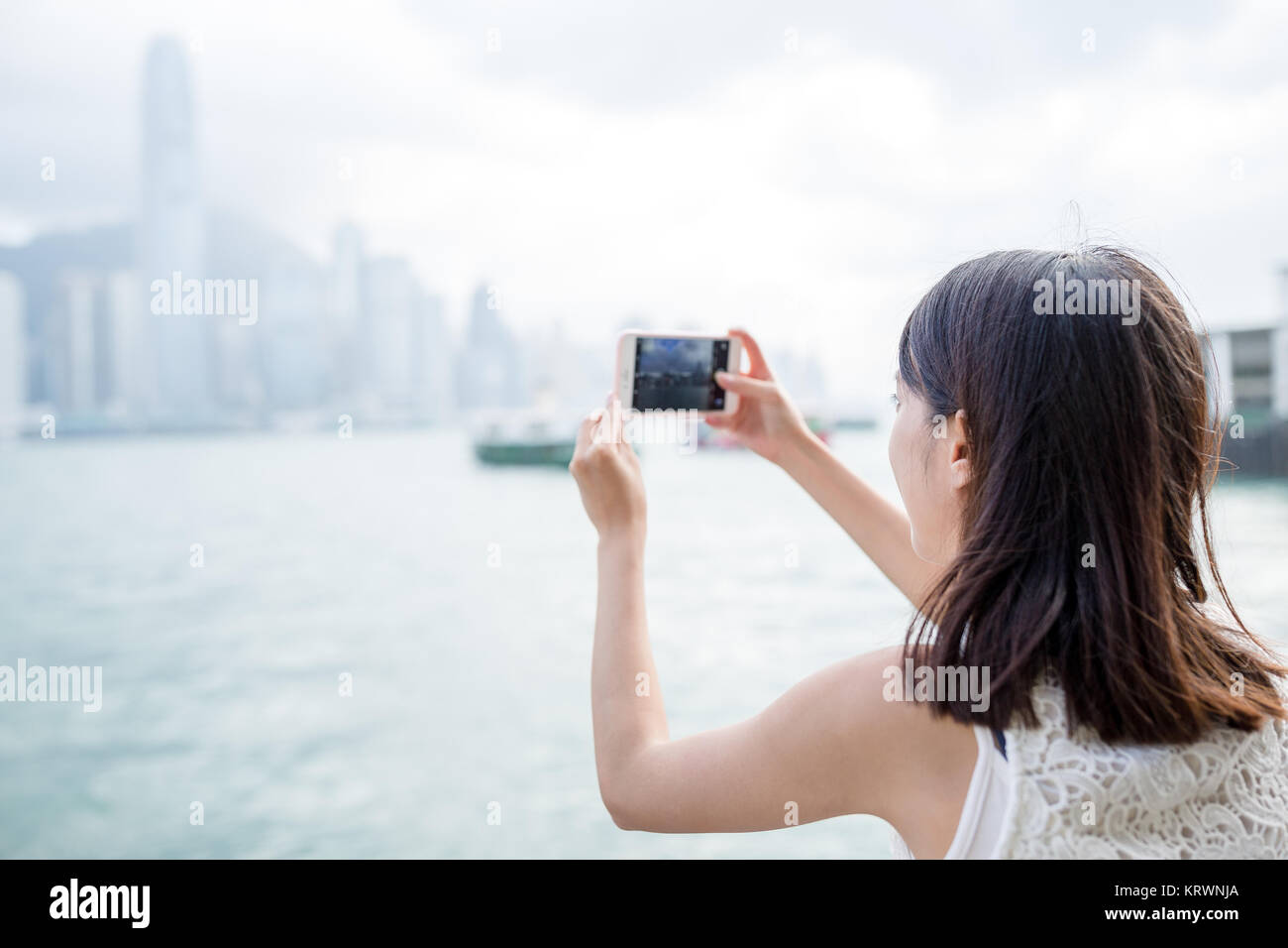 Woman taking photo with cellphone in Hong Kong Stock Photo - Alamy