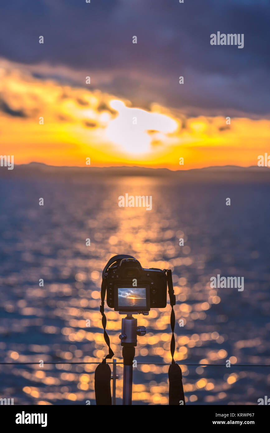 Camera on a tripod capturing the sunset Stock Photo - Alamy