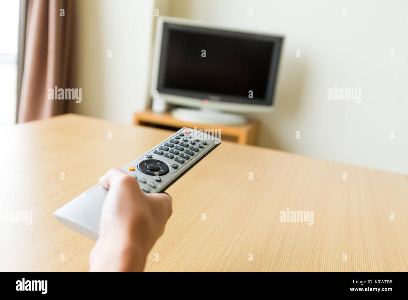 Watching TV and using remote controller Stock Photo - Alamy