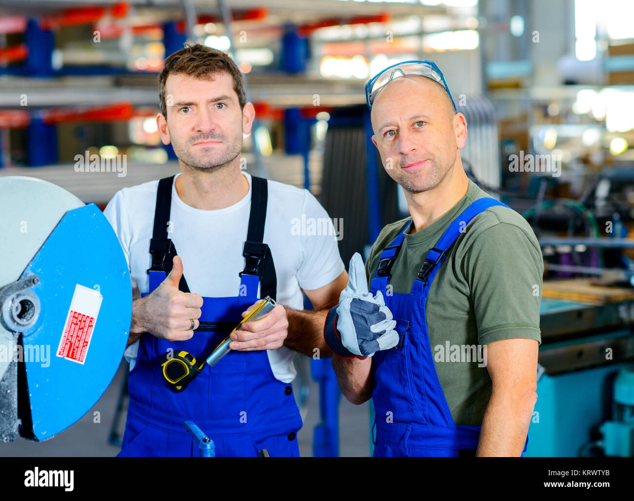 two worker in factory on the machinewith thumb up Stock Photo - Alamy