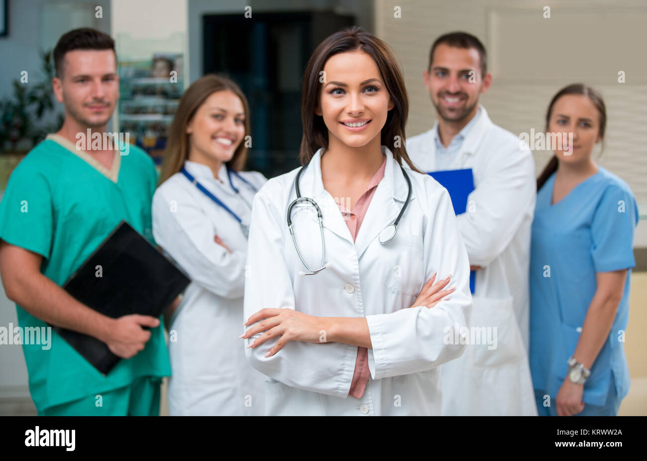 clinic, profession, people, health care and medicine concept - happy group of medics or doctors at hospital corridor Stock Photo