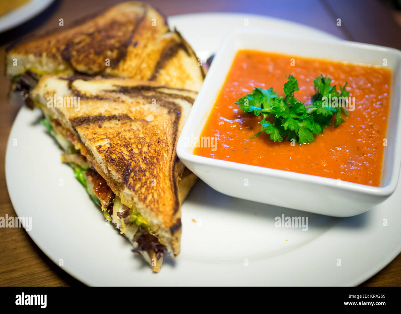 A BLT sandwich (bacon, lettuce, tomato sandwich) on marble rye bread and tomato soup from Culina Cafe in Edmonton, Alberta, Canada. Stock Photo