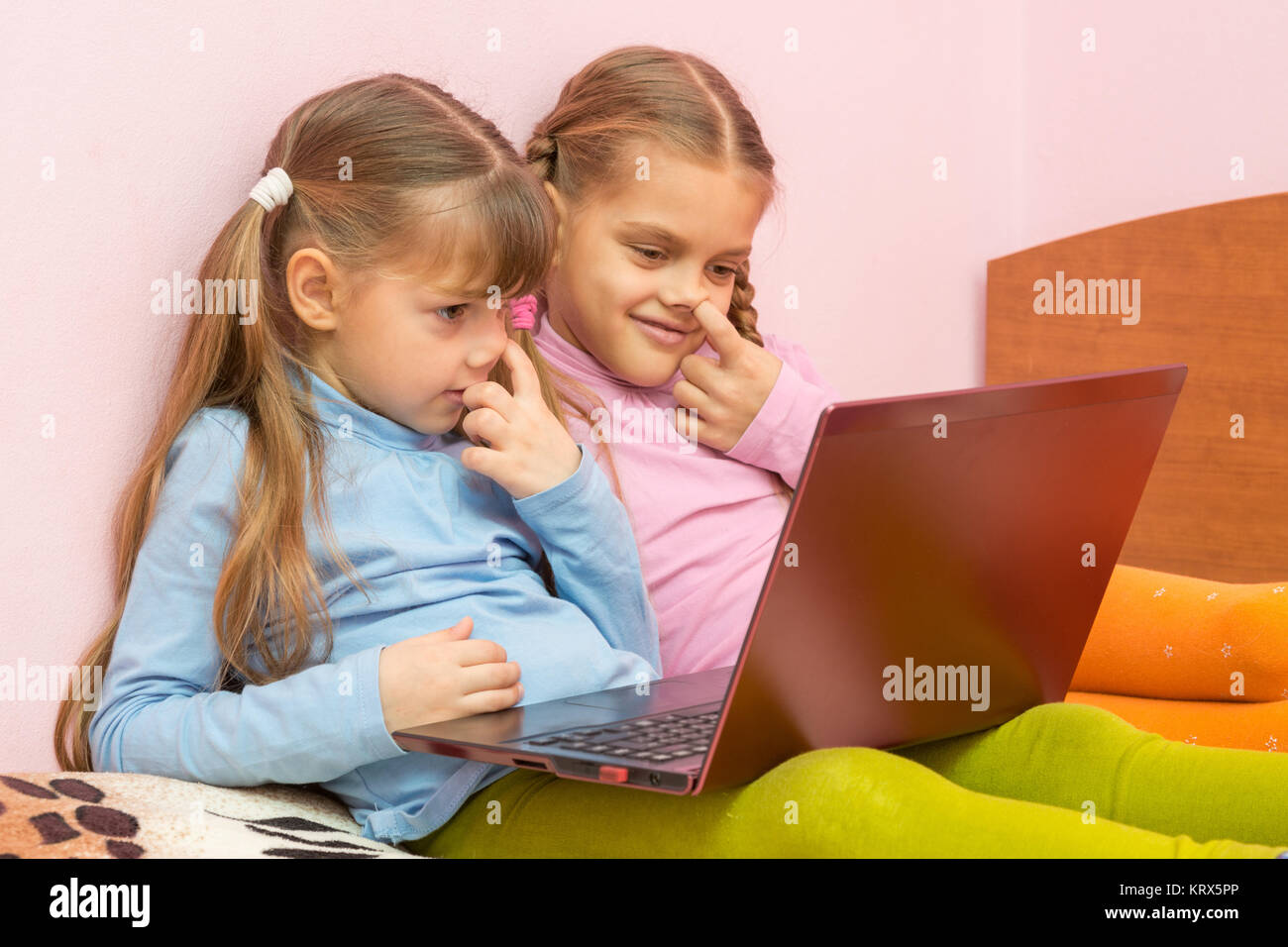 Two girls picking his nose and looking at a laptop screen Stock Photo Alamy