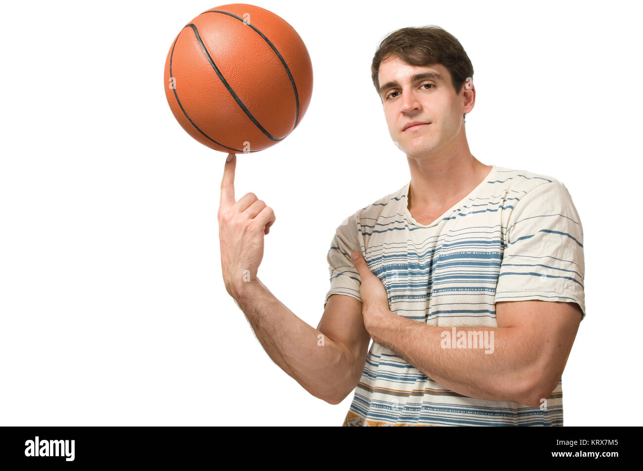 Seitliche Oberkörper-Ansicht eines jungen Mannes im t-Schirt einen Basketball auf dem Zeigefinger balancierend vor weißen Hintergrund. Stock Photo
