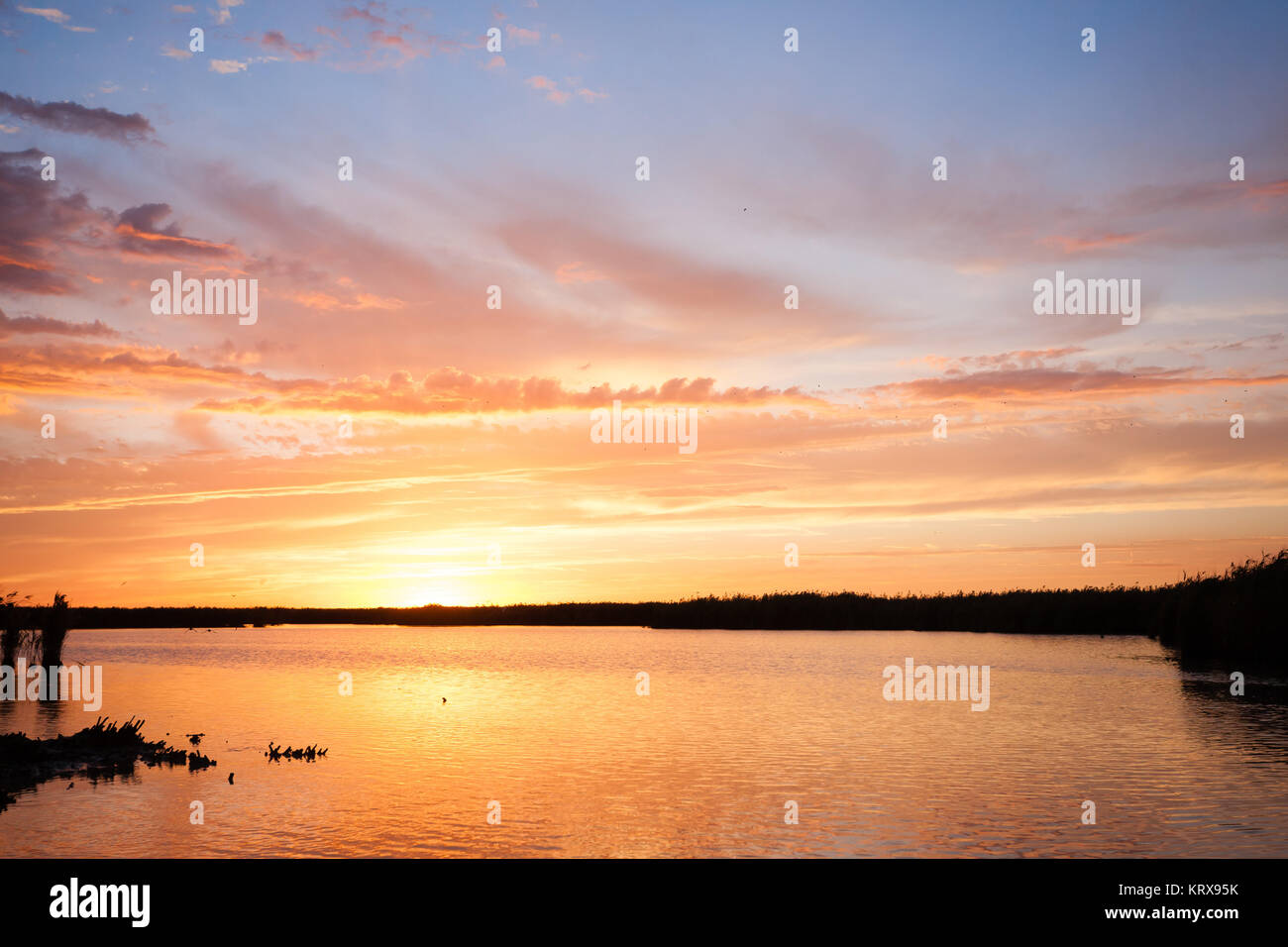 Sunset over water Stock Photo - Alamy