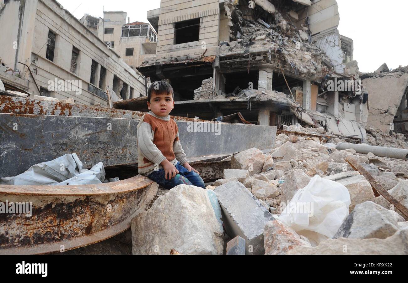 Aleppo. 21st Dec, 2017. A boy sits amid the rubble in the largely destroyed part of Aleppo city in northern Syria, Dec. 21, 2017. Last year's battle of Aleppo was so cubical and a turning point in the course of actions in the Syrian crisis, due to the strategic importance of the city, which was the economic capital of Syria and where most of the country's industry was located. Credit: Ammar Safarjalani/Xinhua/Alamy Live News Stock Photo