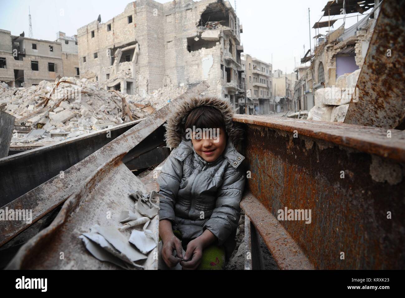 Aleppo. 21st Dec, 2017. A boy plays amid the rubble in the largely destroyed part of Aleppo city in northern Syria, Dec. 21, 2017. Last year's battle of Aleppo was so cubical and a turning point in the course of actions in the Syrian crisis, due to the strategic importance of the city, which was the economic capital of Syria and where most of the country's industry was located. Credit: Ammar Safarjalani/Xinhua/Alamy Live News Stock Photo