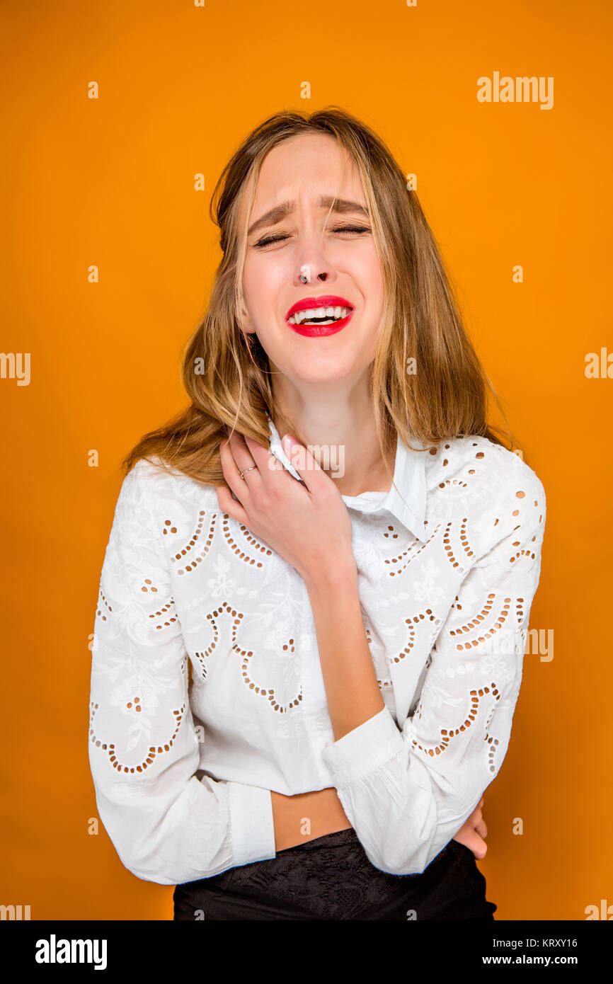The serious frustrated young beautiful business woman on orange background Stock Photo