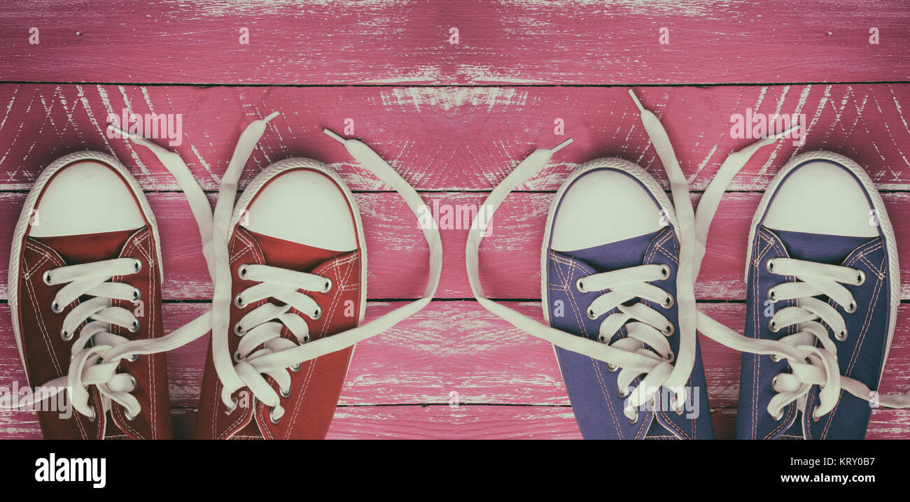 Two pairs of worn sneakers on a pink old wooden surface Stock Photo - Alamy