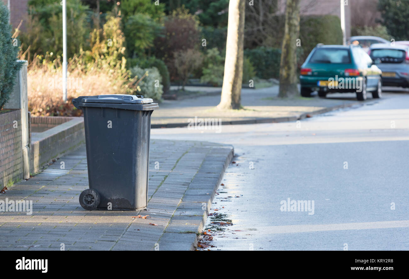 Rolling trash can standing at the side of the road Stock Photo Alamy