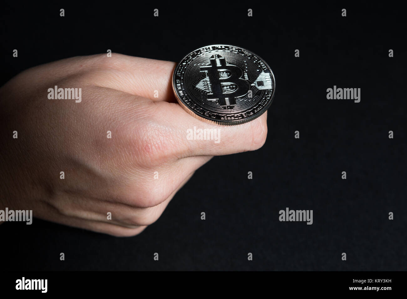 Woman hand flipping a bitcoin for head or tail good luck concept Stock