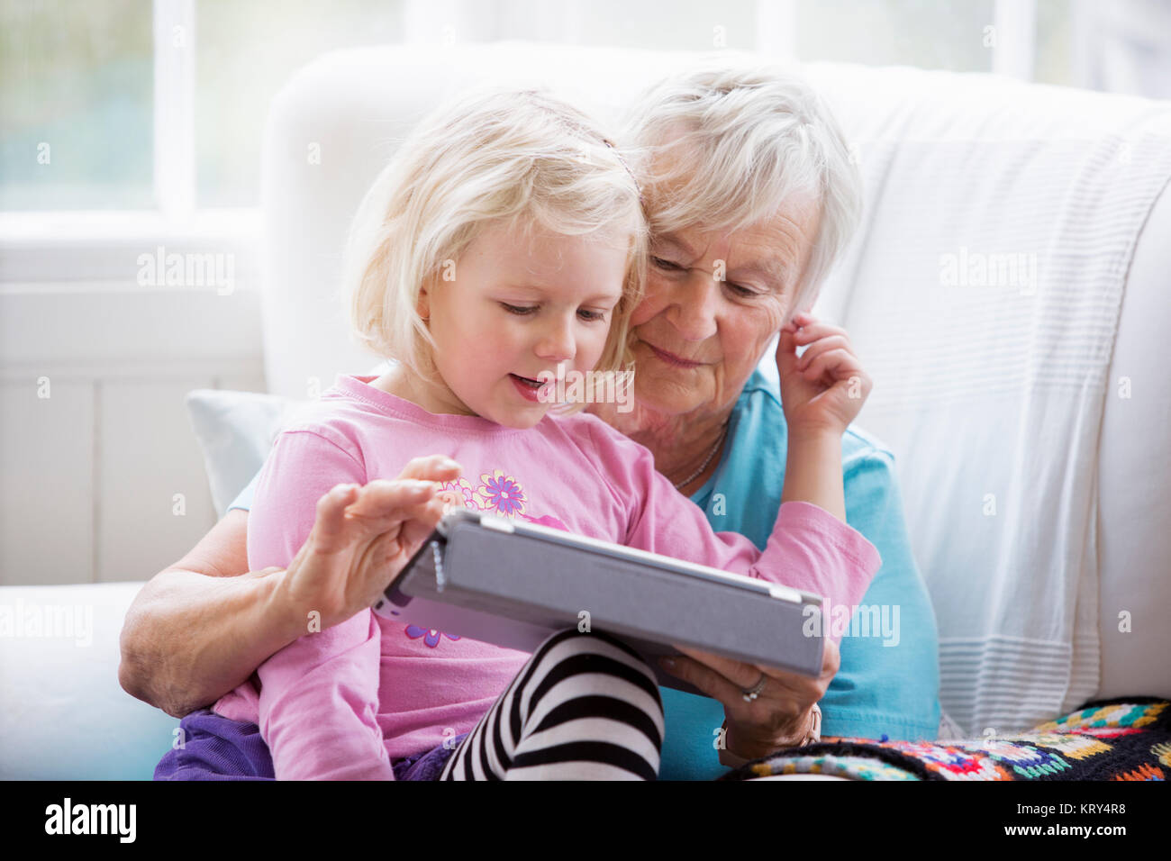 Grandmother and Granddaughter looking at a tablet Stock Photo