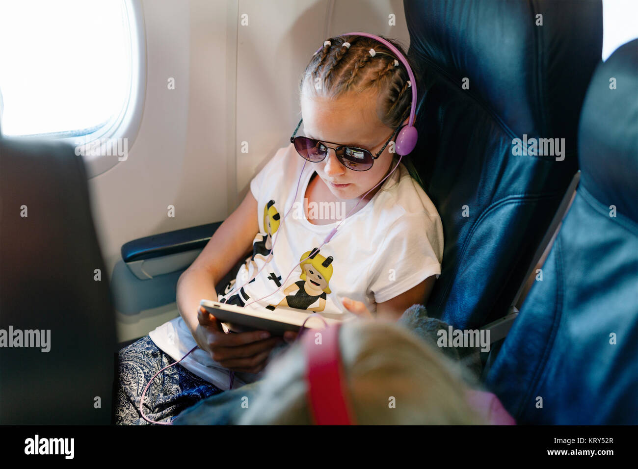 Girl holding a tablet on a plane Stock Photo