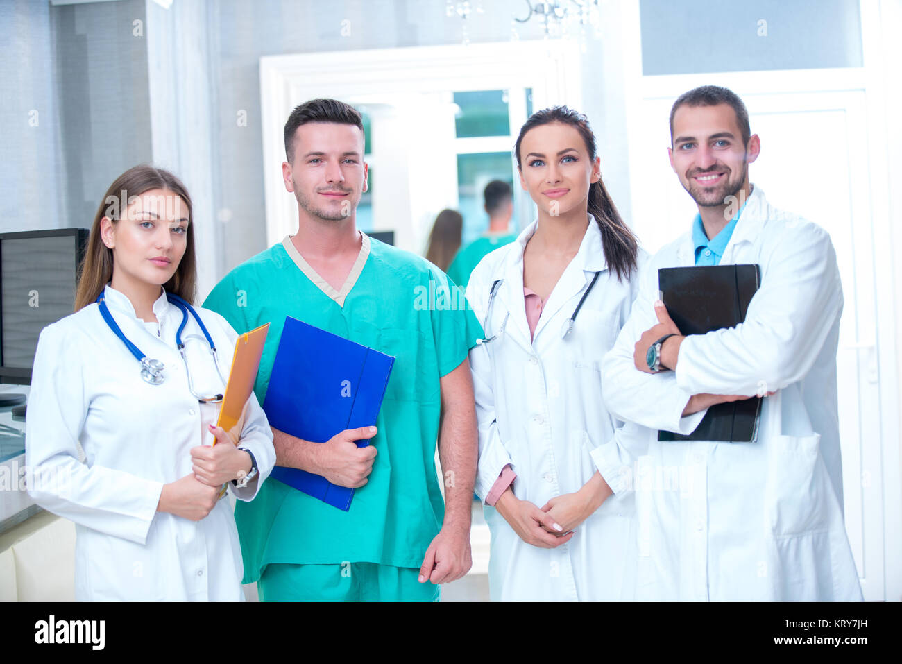clinic, profession, people, health care and medicine concept - happy group of medics or doctors at hospital corridor Stock Photo