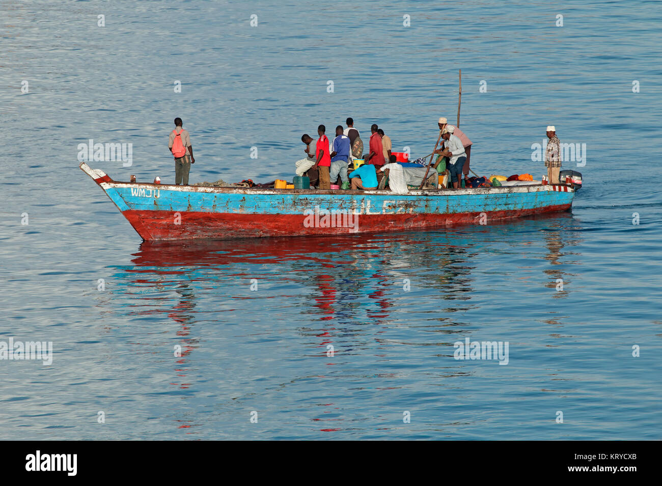 STONE TOWN, ZANZIBAR, TANZANIA - OCTOBER 31, 2014: Returning fishermen on a wooden fishing boat entering the Stone Town harbor Stock Photo
