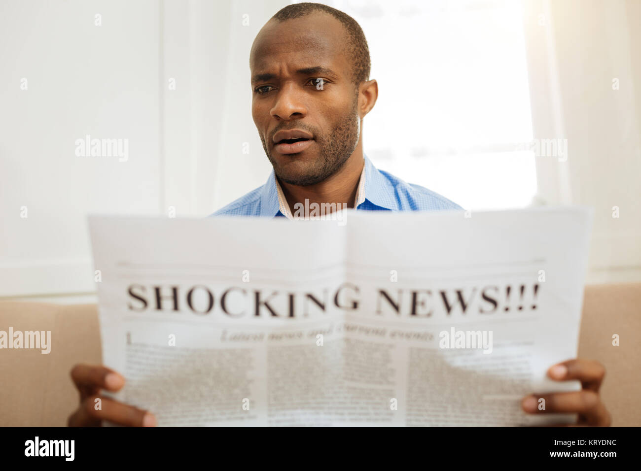 Shocked man reading a newspaper Stock Photo Alamy