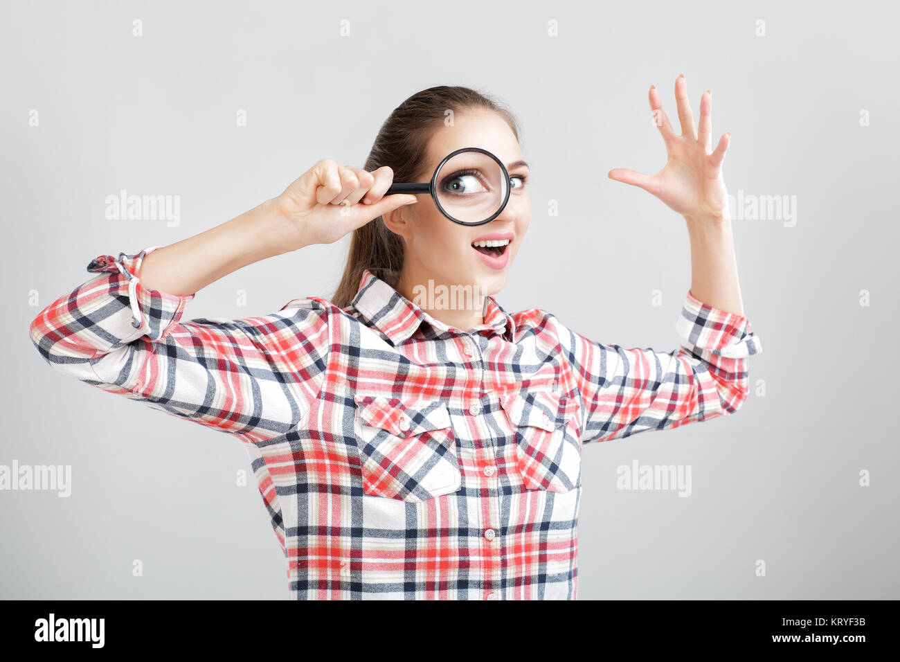 woman looks through a magnifying glass Stock Photo - Alamy