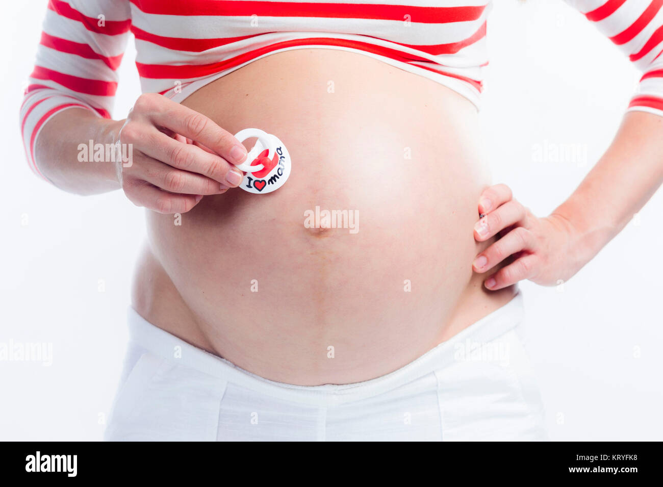 Schwangere Frau mit Schnuller am Babybauch - pregnant woman with dummy Stock Photo