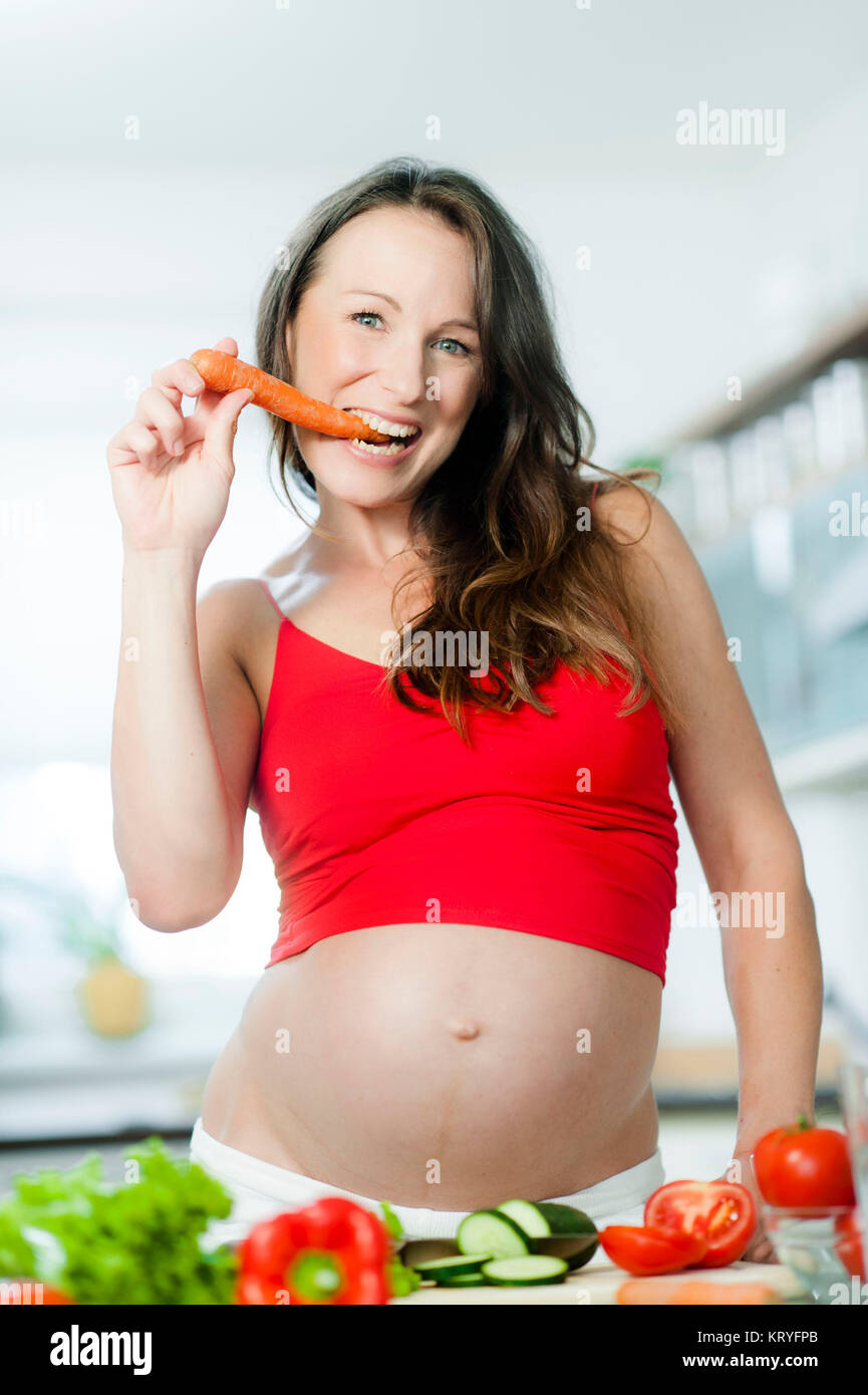 Schwangere Frau mit Gemüse beim Kochen - pregnant woman with vegetables Stock Photo