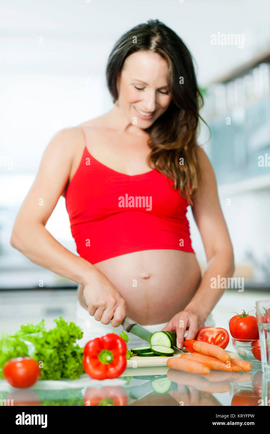 Schwangere Frau beim Kochen mit Gemüse - pregnant woman cooking vegetables Stock Photo