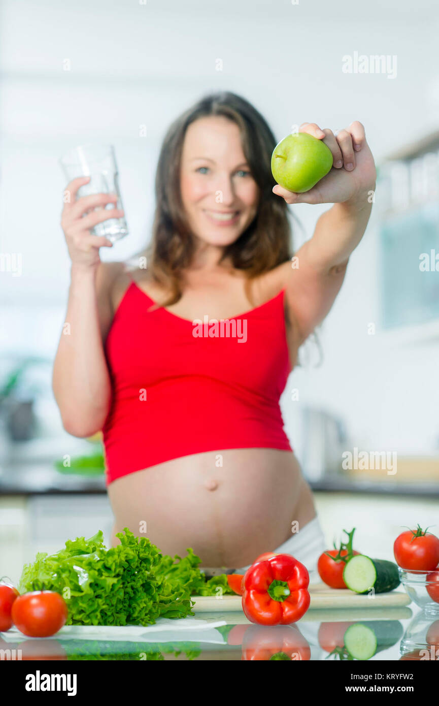Schwangere Frau ernährt sich gesund - pregnant woman with water and an apple Stock Photo