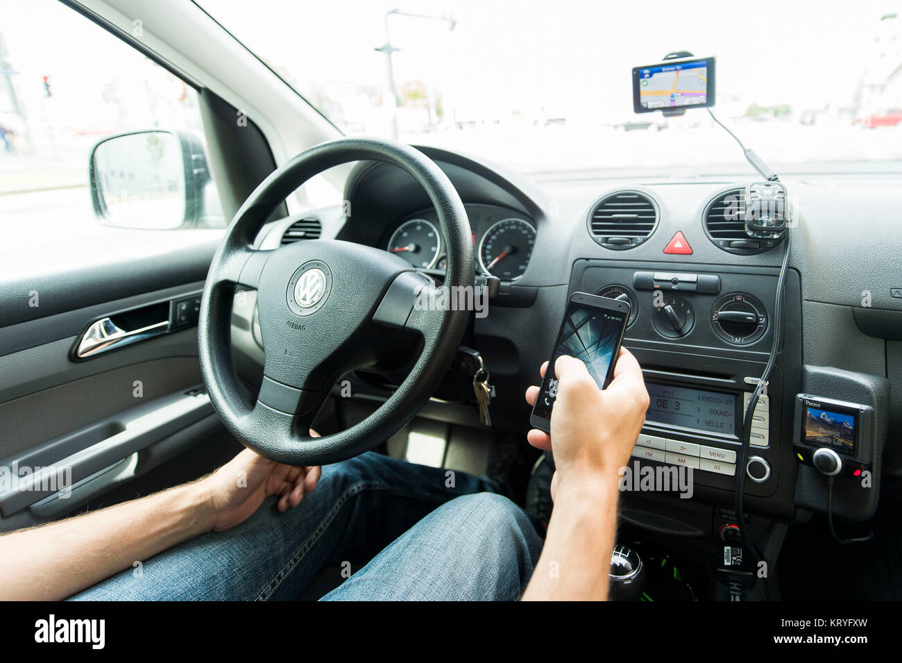Autofahrer bedient Handy während der Fahrt - using a mobile while driving a car Stock Photo