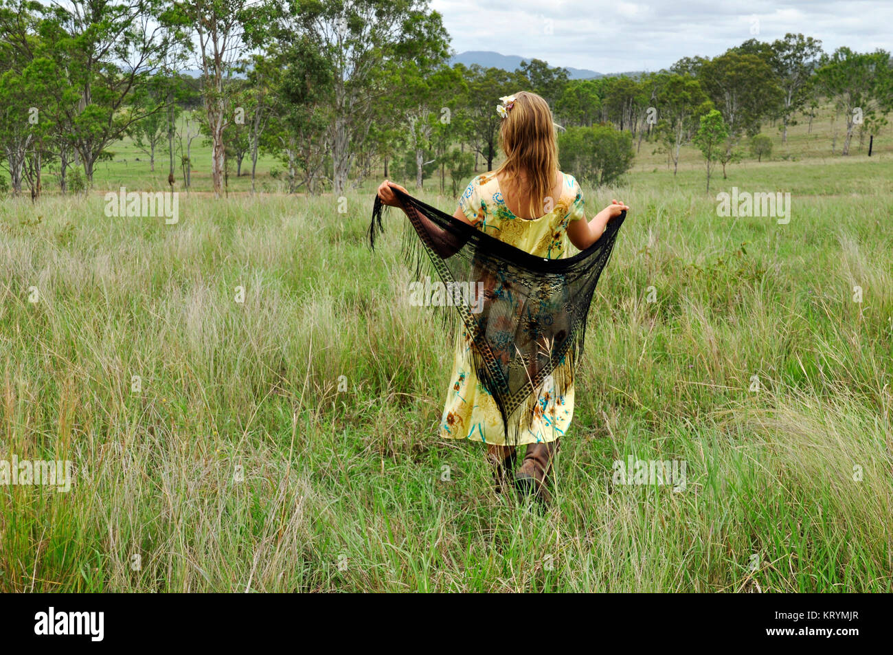 YOUNG WOMAN WALKING IN A FIELD Stock Photo - Alamy