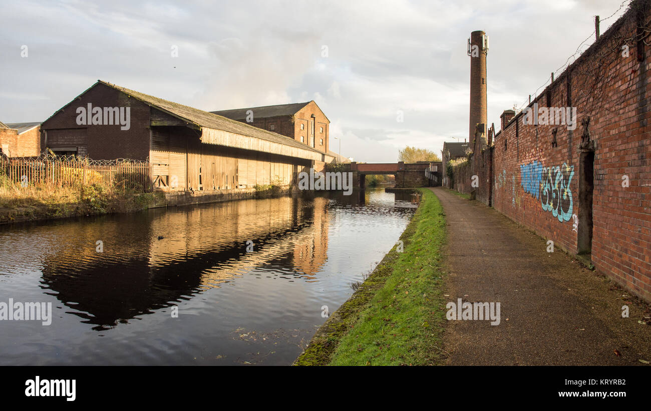 Liverpool, England, UK - November 12, 2016: Run down and derelict industrial warehouses and factory buildings stand beside the Leeds and Liverpool Can Stock Photo