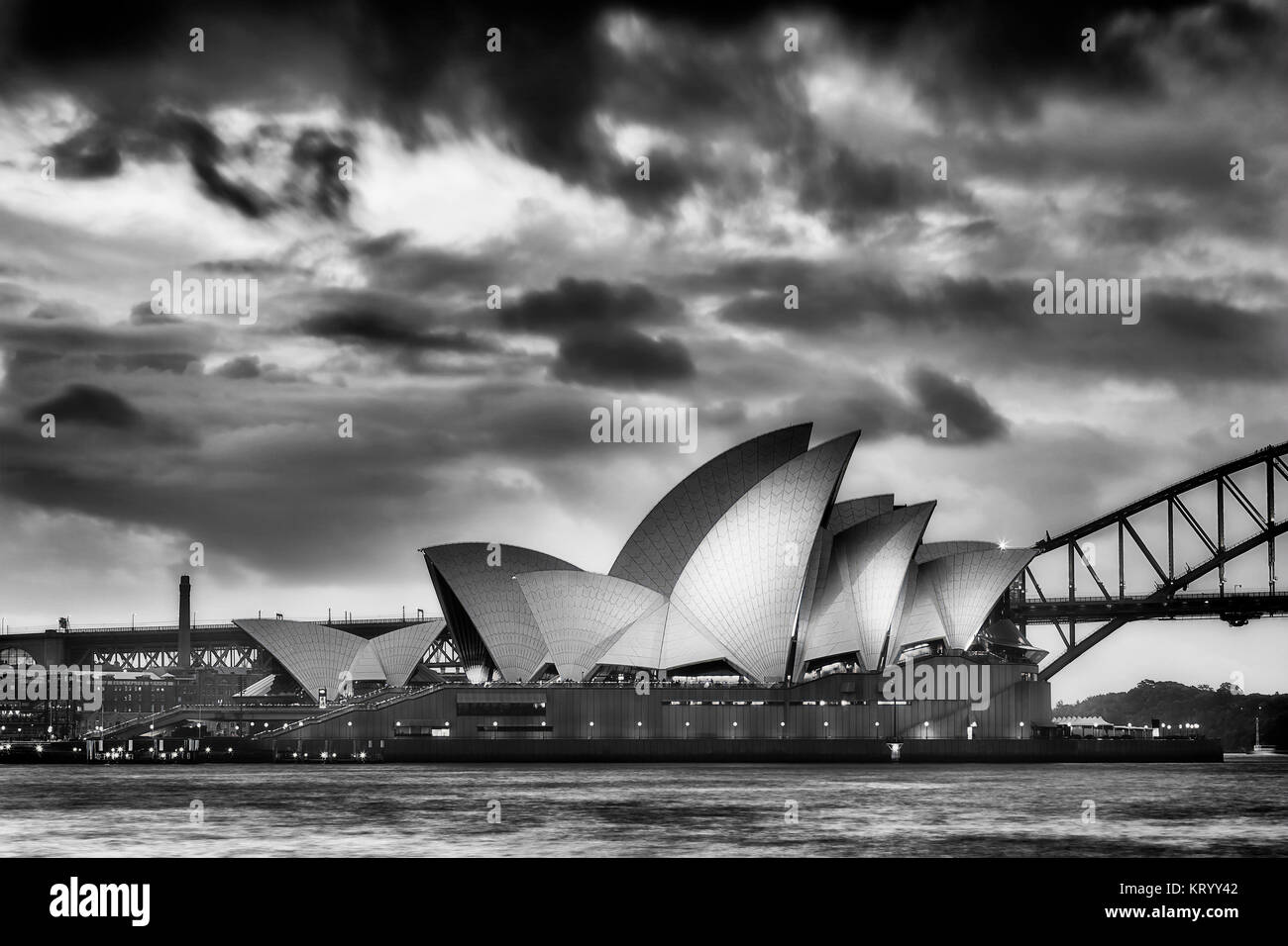 Sydney, Australia - 19 March 2017: Magical sunset over world famous landmark - Sydney Opera house and Harbour Bridge. Side view of illuminated opera i Stock Photo