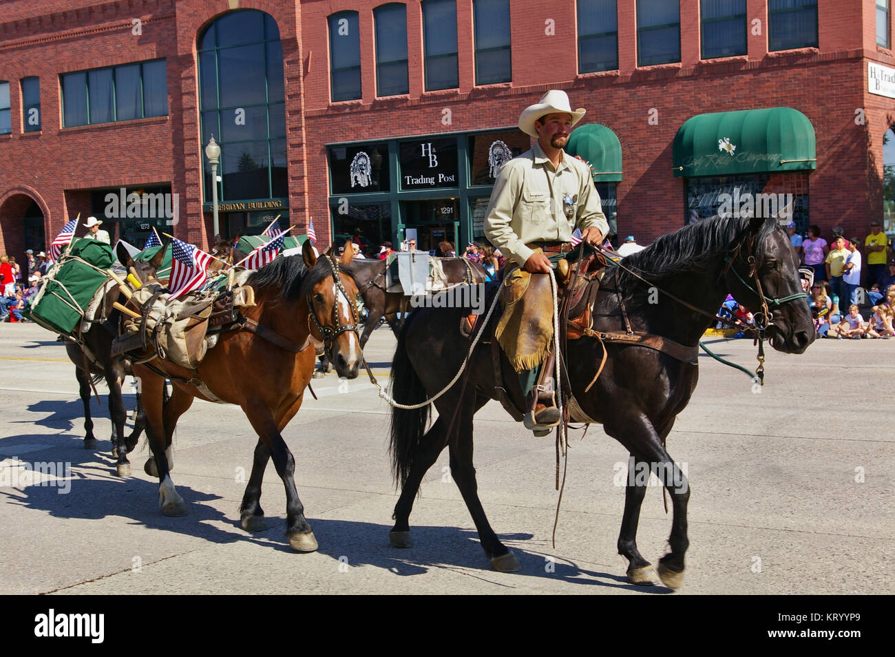 Cody, Wyoming, USA - July 4th, 2009 - Member of the US Forest Service mounted on his horse leading several packhorses in the Independence Day Parade Stock Photo