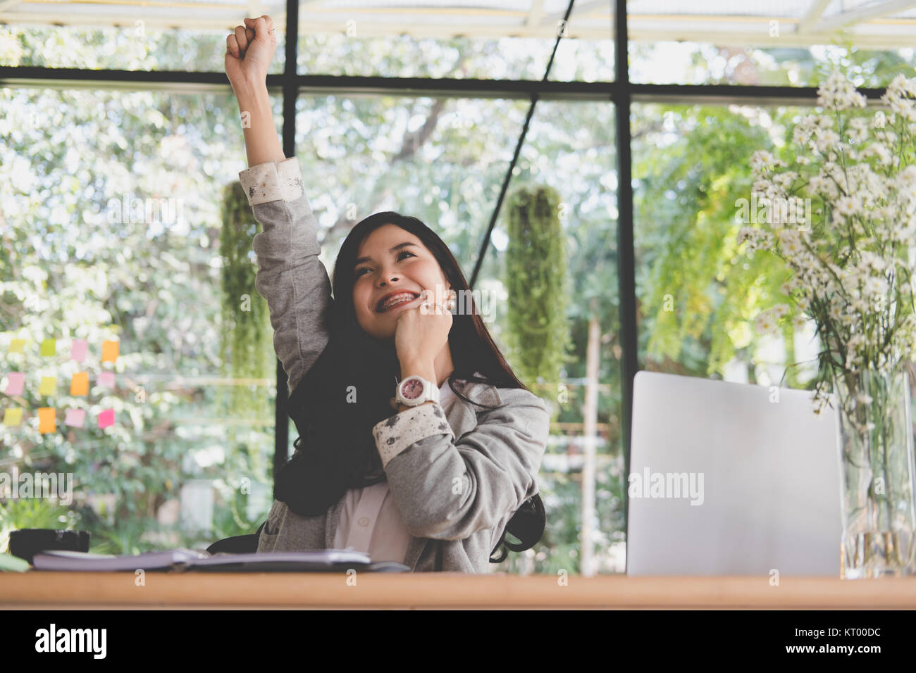 young start up woman raise fist with yes gesture at office. freelance female entrepreneur glad with successful project. businesswoman working at workp Stock Photo