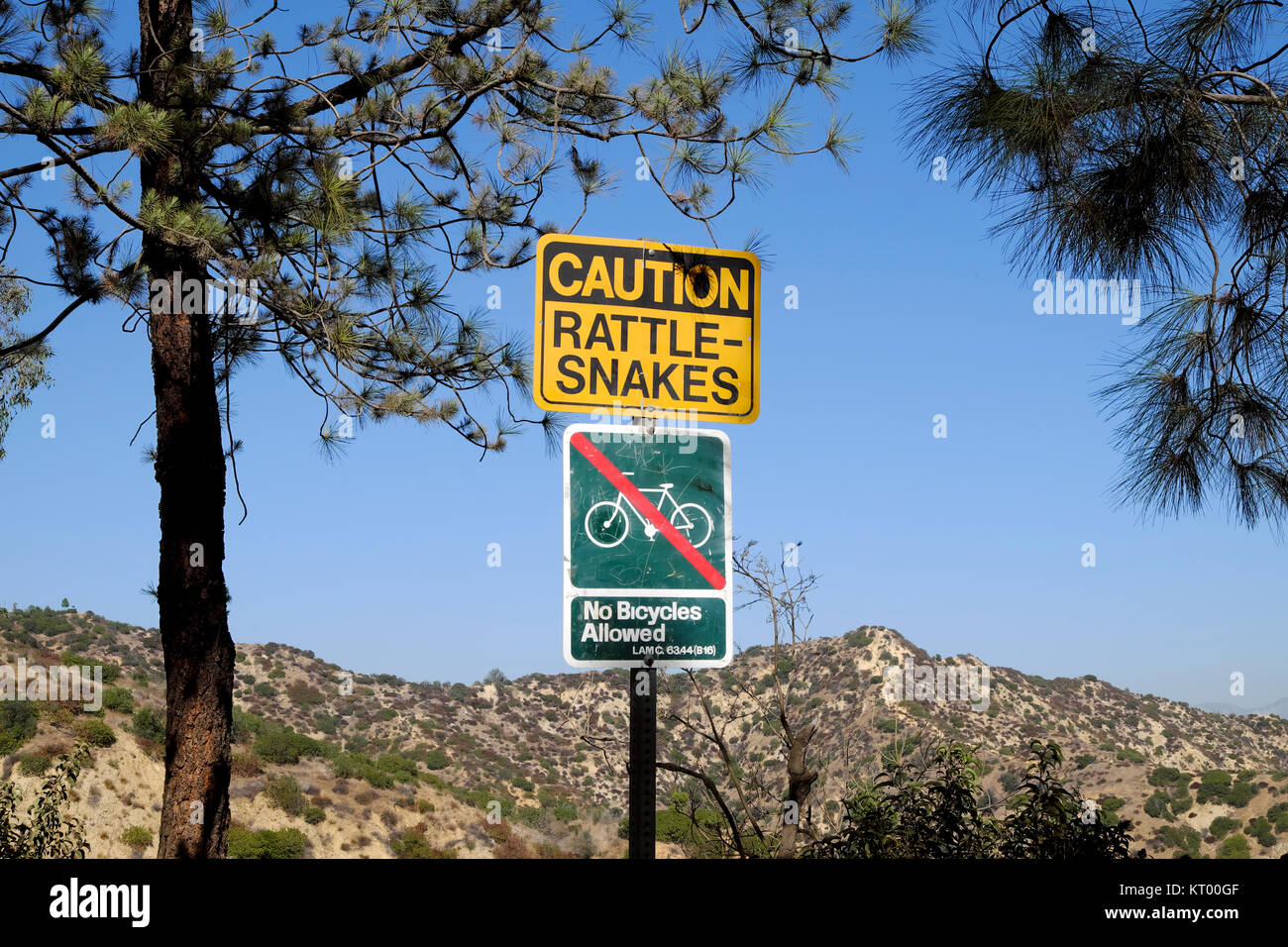 Caution Rattlesnakes sign and no cycling sign at Griffith Park hills near the Griffith Observatory in Los Angeles California USA  KATHY DEWITT Stock Photo