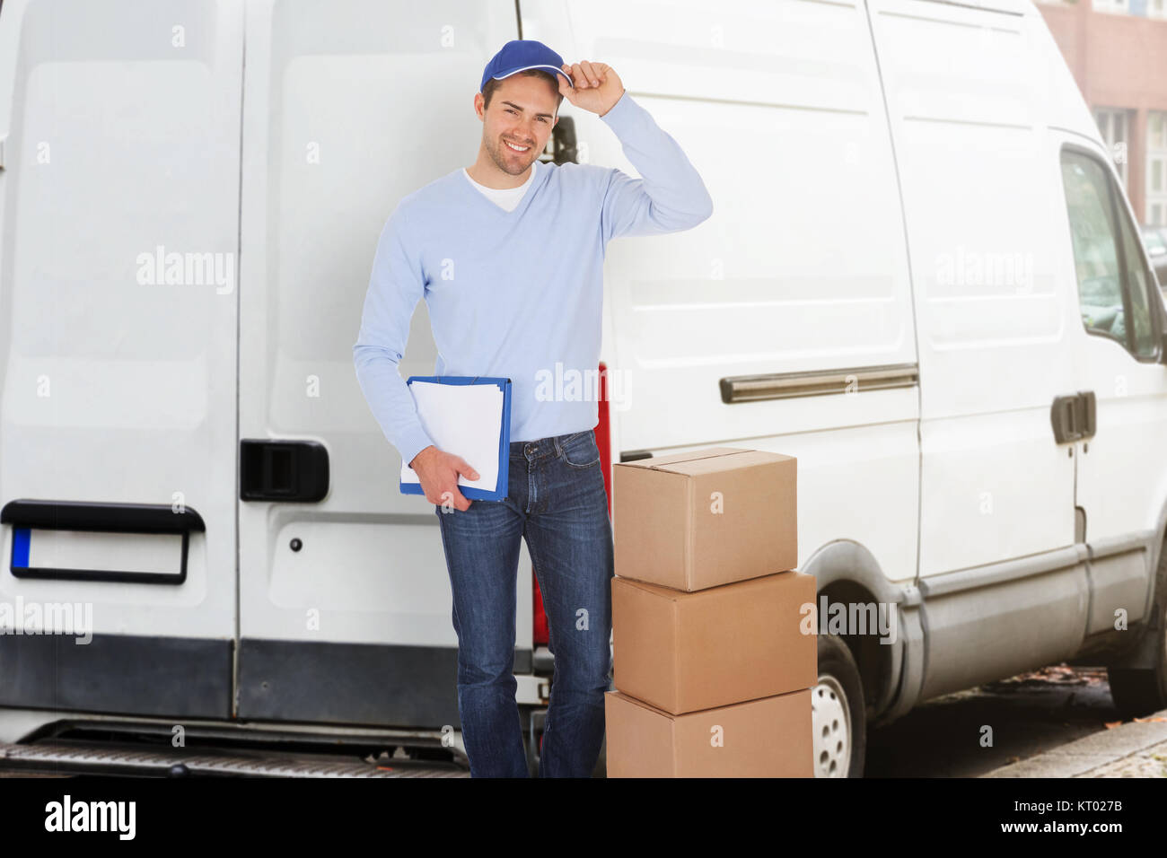 Smiling young delivery man Stock Photo - Alamy