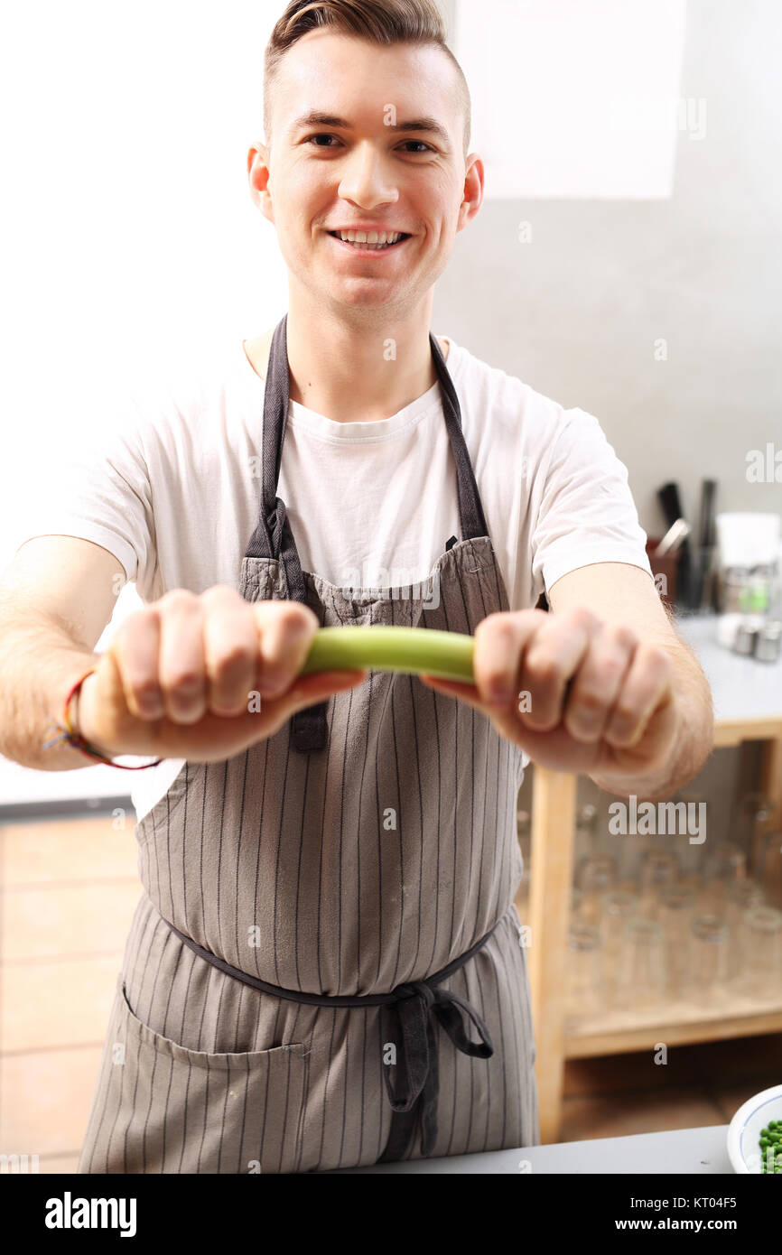 celery in the kitchen. celery cook holds in his hand a vegetable. Stock Photo