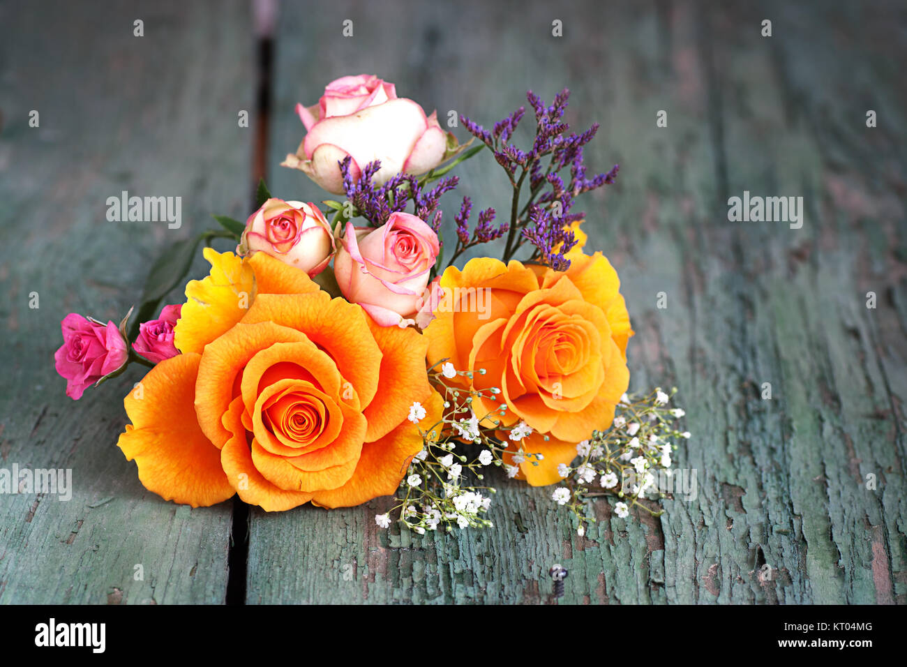 Colorful bouquet of roses on an old wooden table Stock Photo